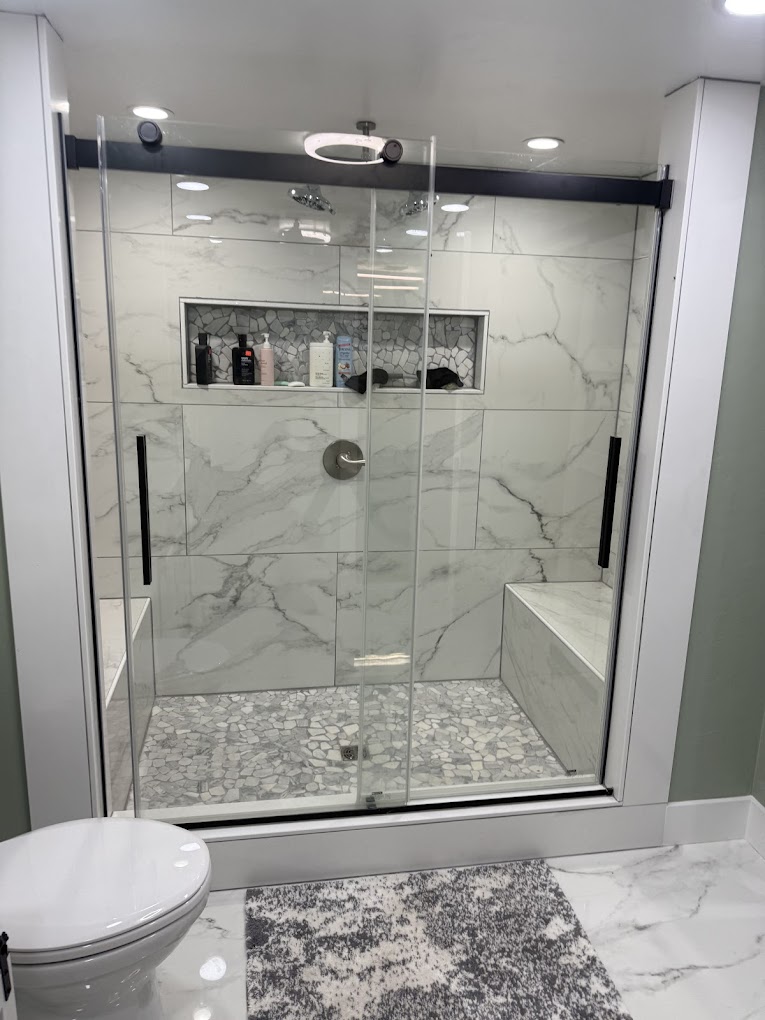 Custom tiled walk-in shower with marble walls and pebble floor